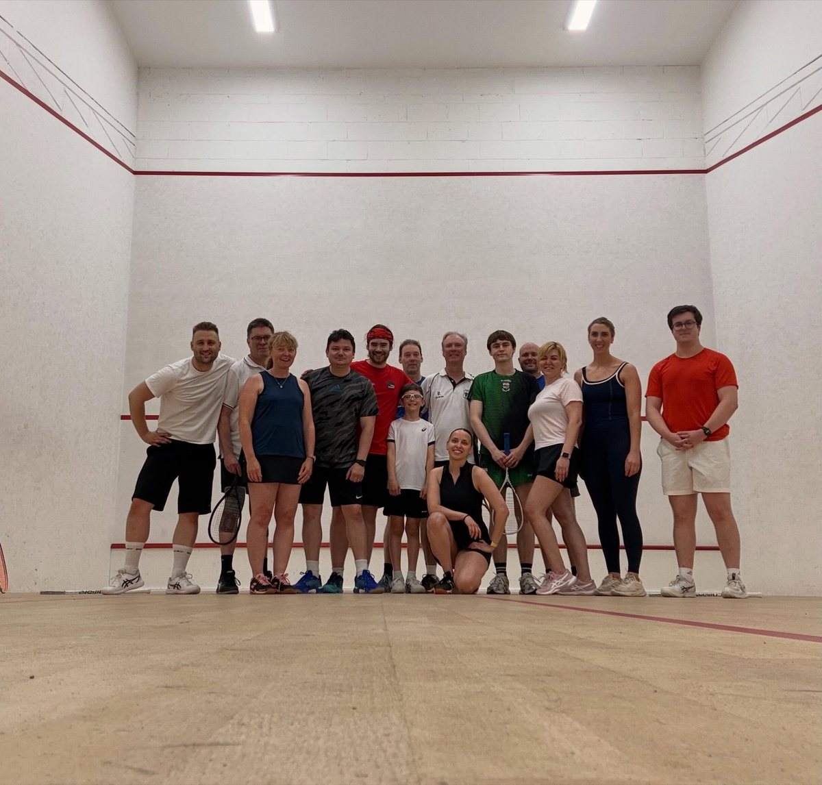 A mixed group of Belvedere Squash players on court